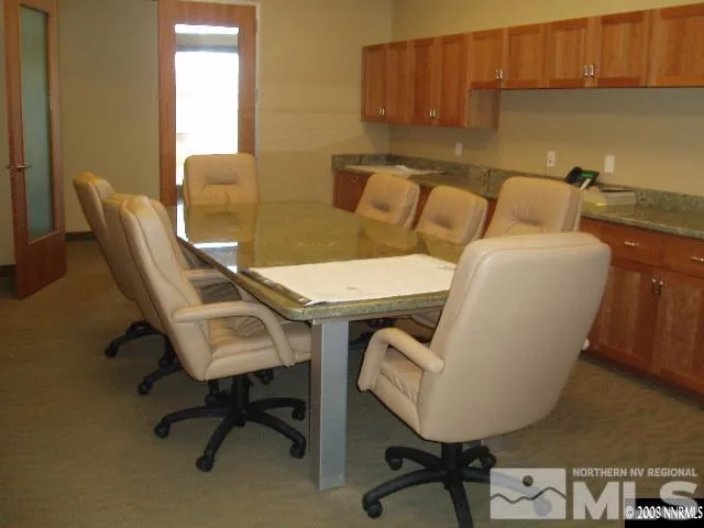a view of a workspace with furniture and a window