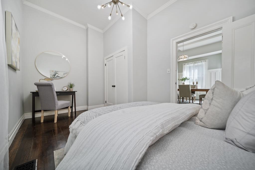 1731 11th Street Oakland, CA 94607 - Photo 14 of 35 a spacious bedroom with a bed and a chandelier