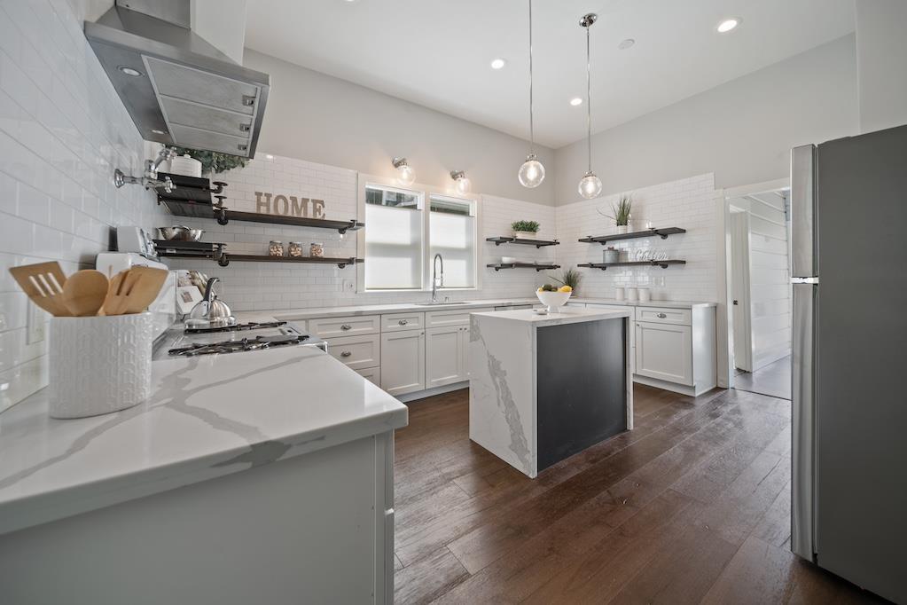 1731 11th Street Oakland, CA 94607 - Photo 15 of 35 a kitchen with kitchen island a sink a stove and a refrigerator