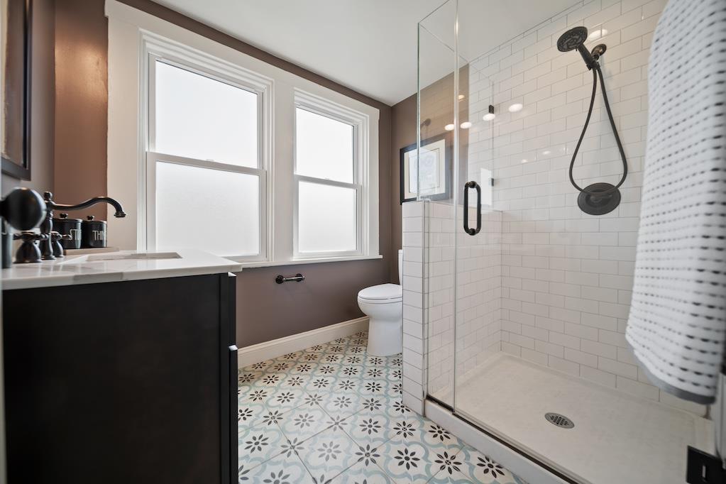 1731 11th Street Oakland, CA 94607 - Photo 23 of 35 a bathroom with a granite countertop sink a toilet and shower