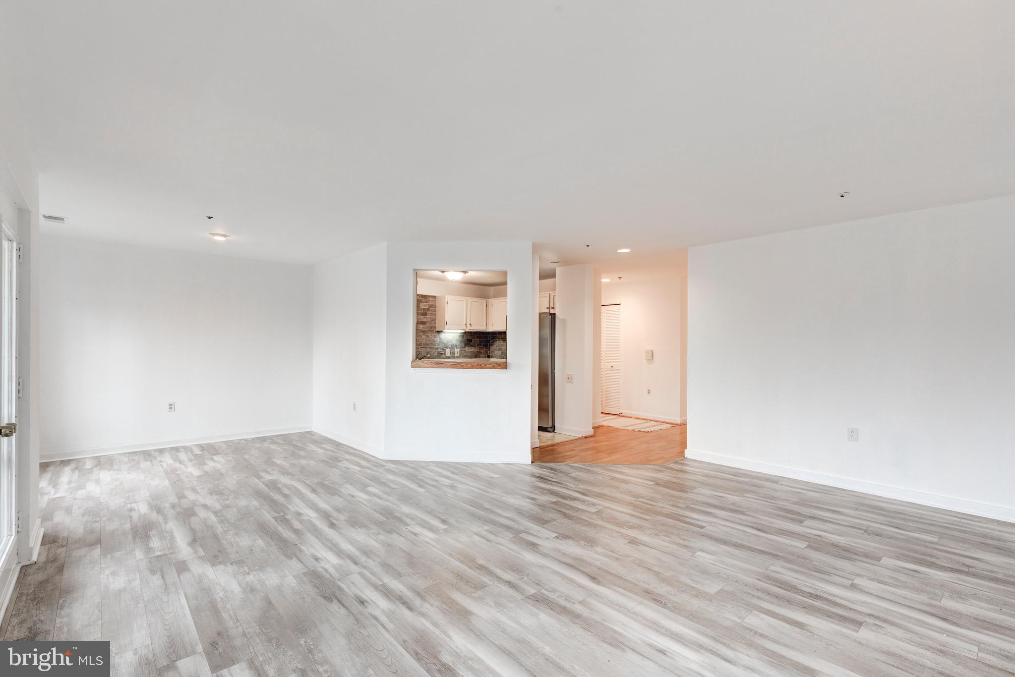 385 Pleasanton Road, Unit B22 Westminster, MD 21157 - Photo 14 of 35 a view of an empty room with wooden floor and a window