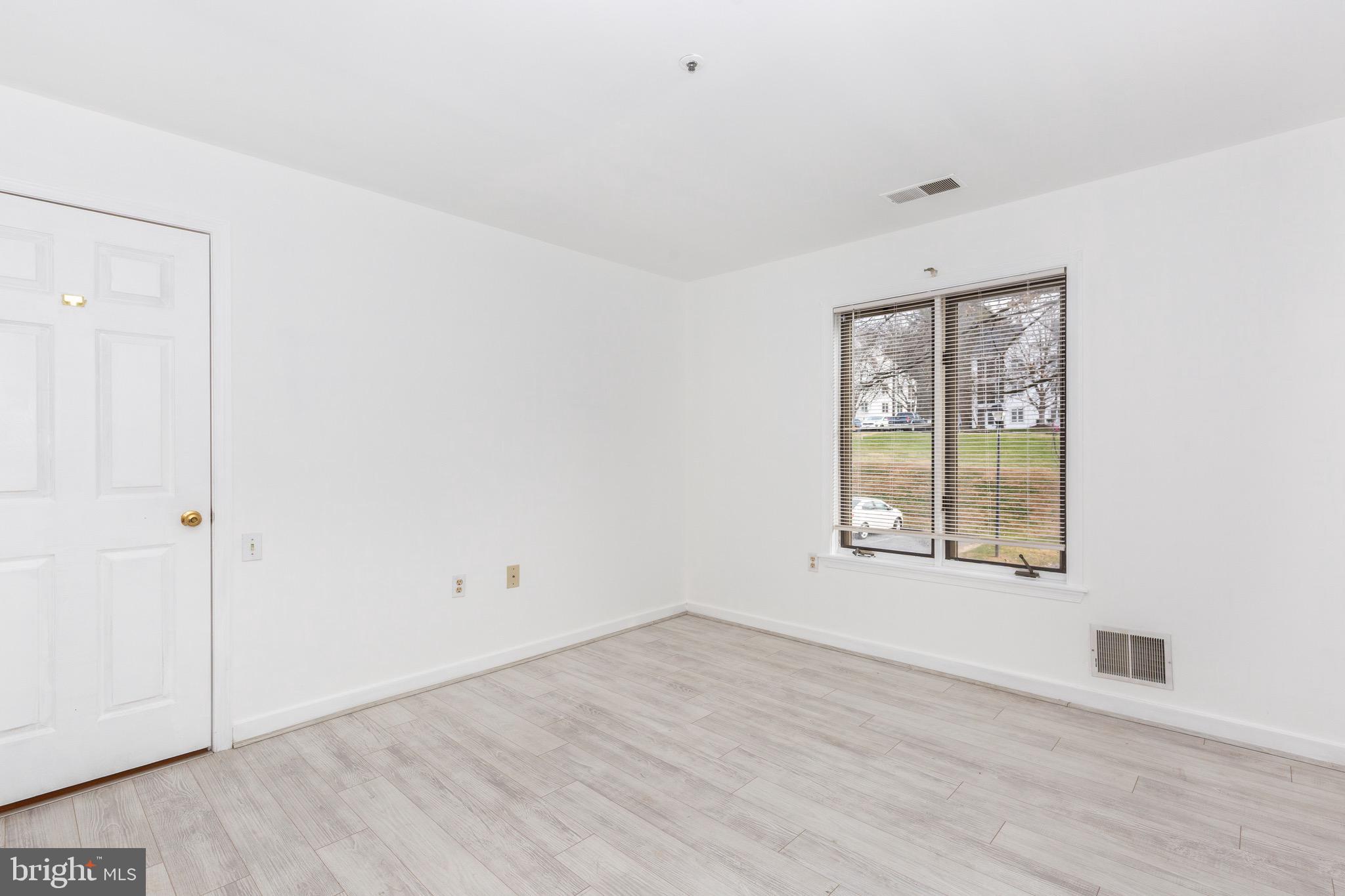 385 Pleasanton Road, Unit B22 Westminster, MD 21157 - Photo 23 of 35 an empty room with wooden floor and windows
