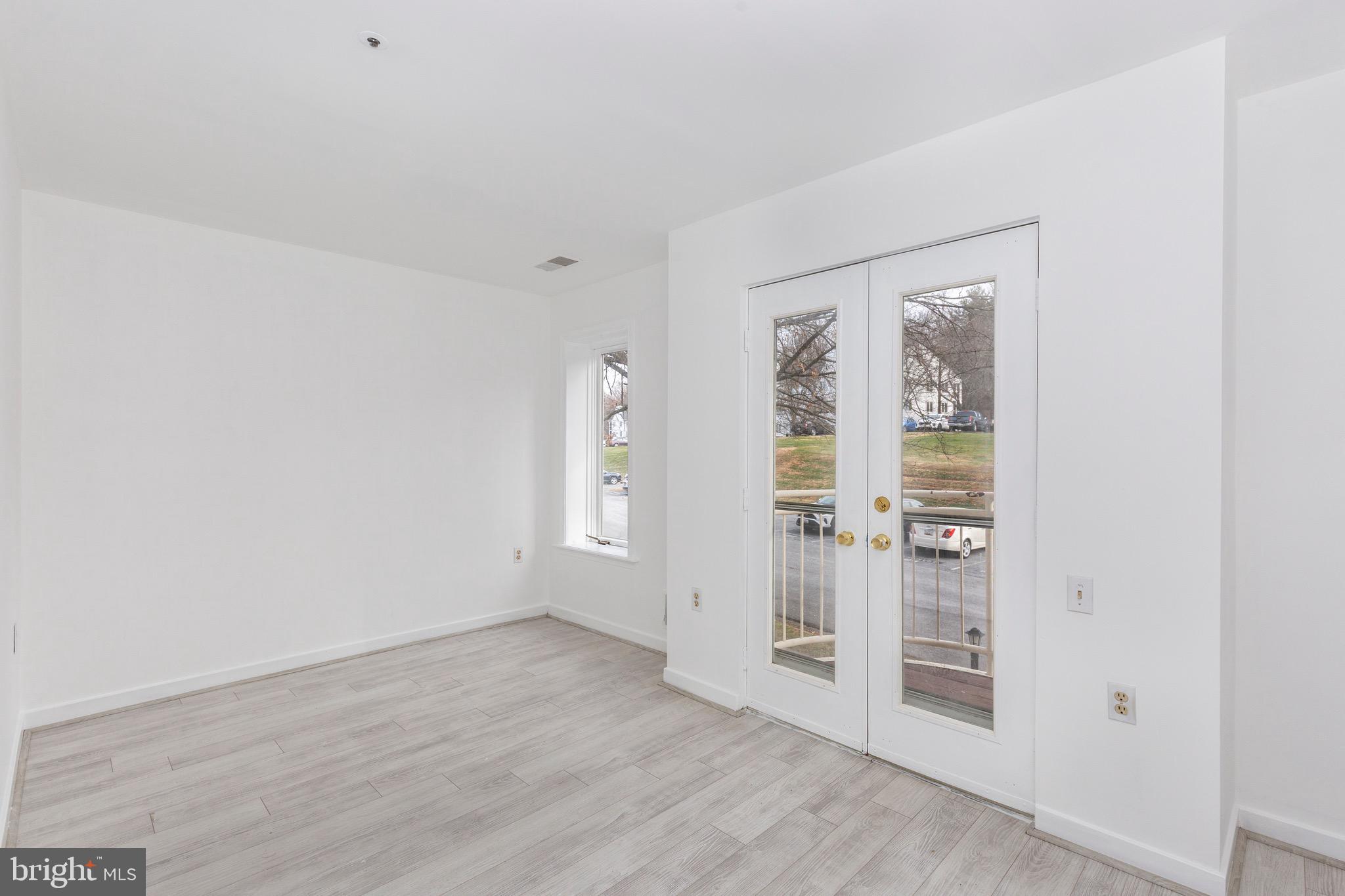 385 Pleasanton Road, Unit B22 Westminster, MD 21157 - Photo 29 of 35 an empty room with wooden floor and windows