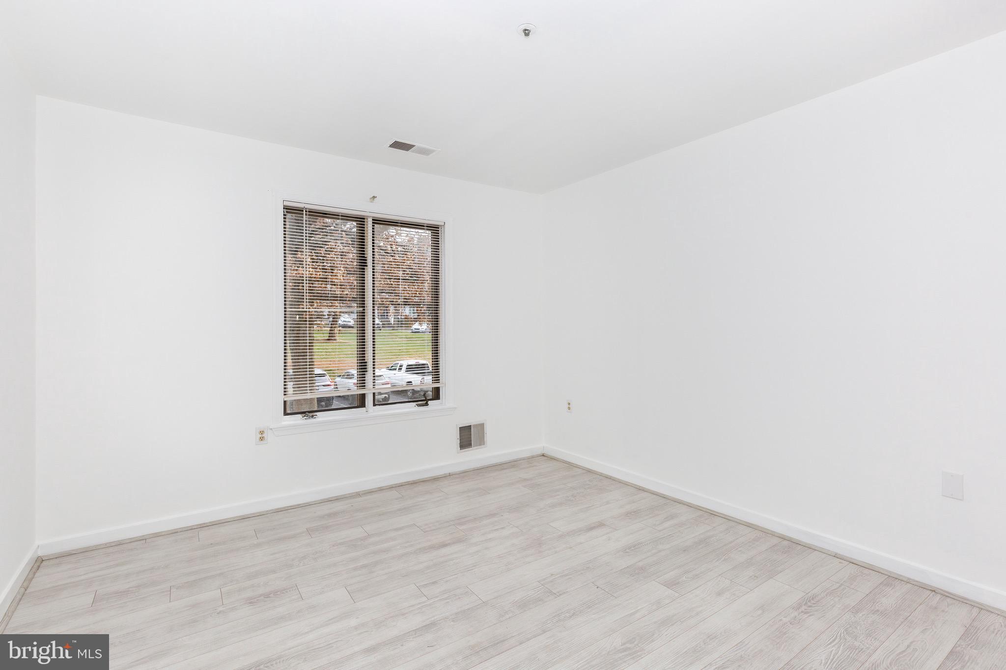 385 Pleasanton Road, Unit B22 Westminster, MD 21157 - Photo 30 of 35 an empty room with wooden floor and windows