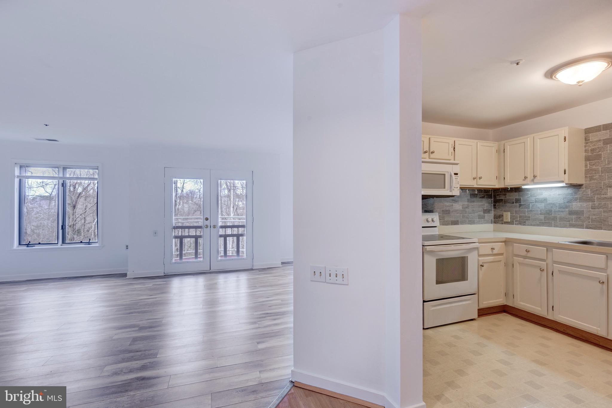 385 Pleasanton Road, Unit B22 Westminster, MD 21157 - Photo 7 of 35 a kitchen with granite countertop white cabinets and white appliances