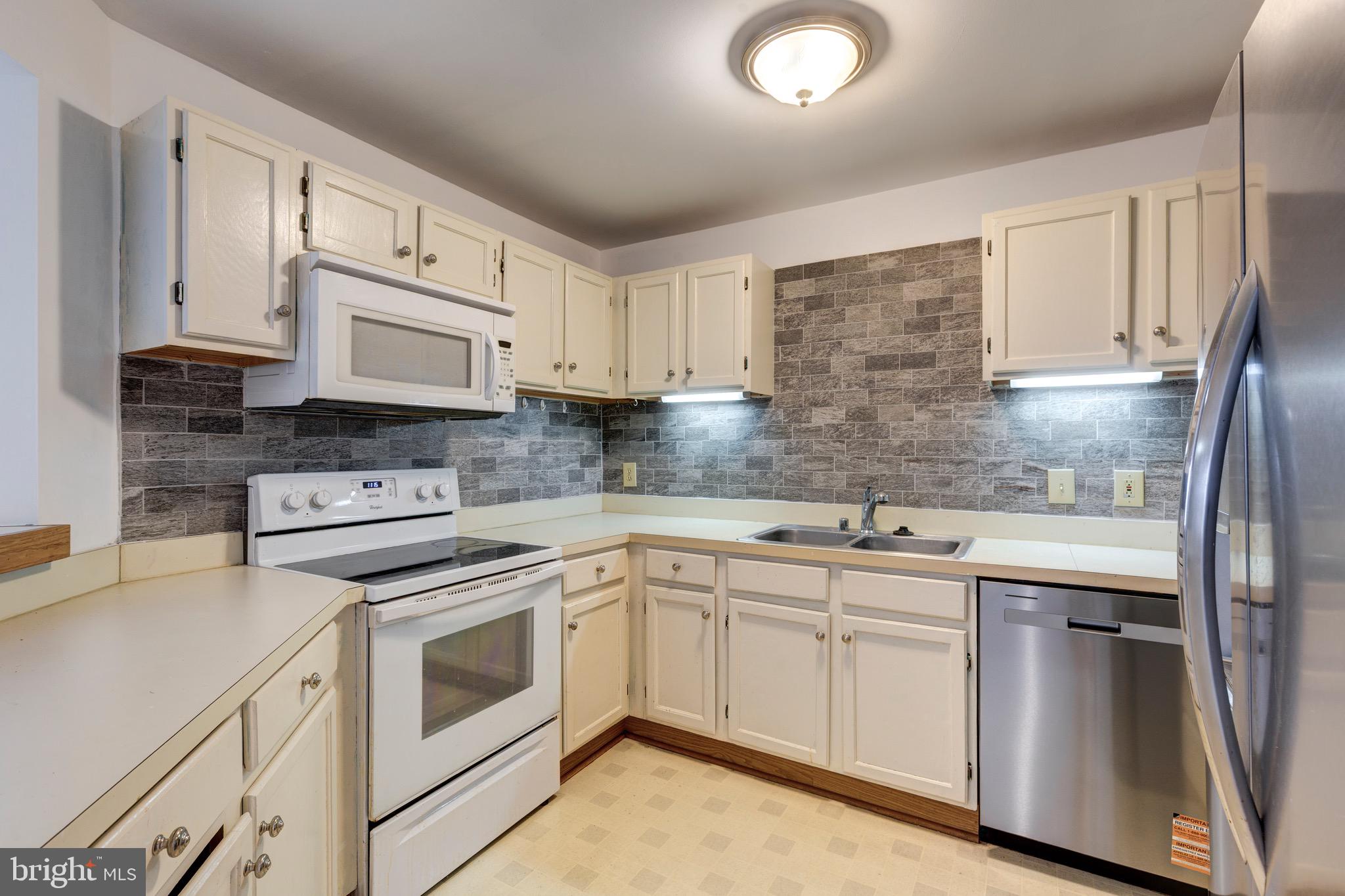 385 Pleasanton Road, Unit B22 Westminster, MD 21157 - Photo 8 of 35 a kitchen with cabinets appliances a sink and a counter top space