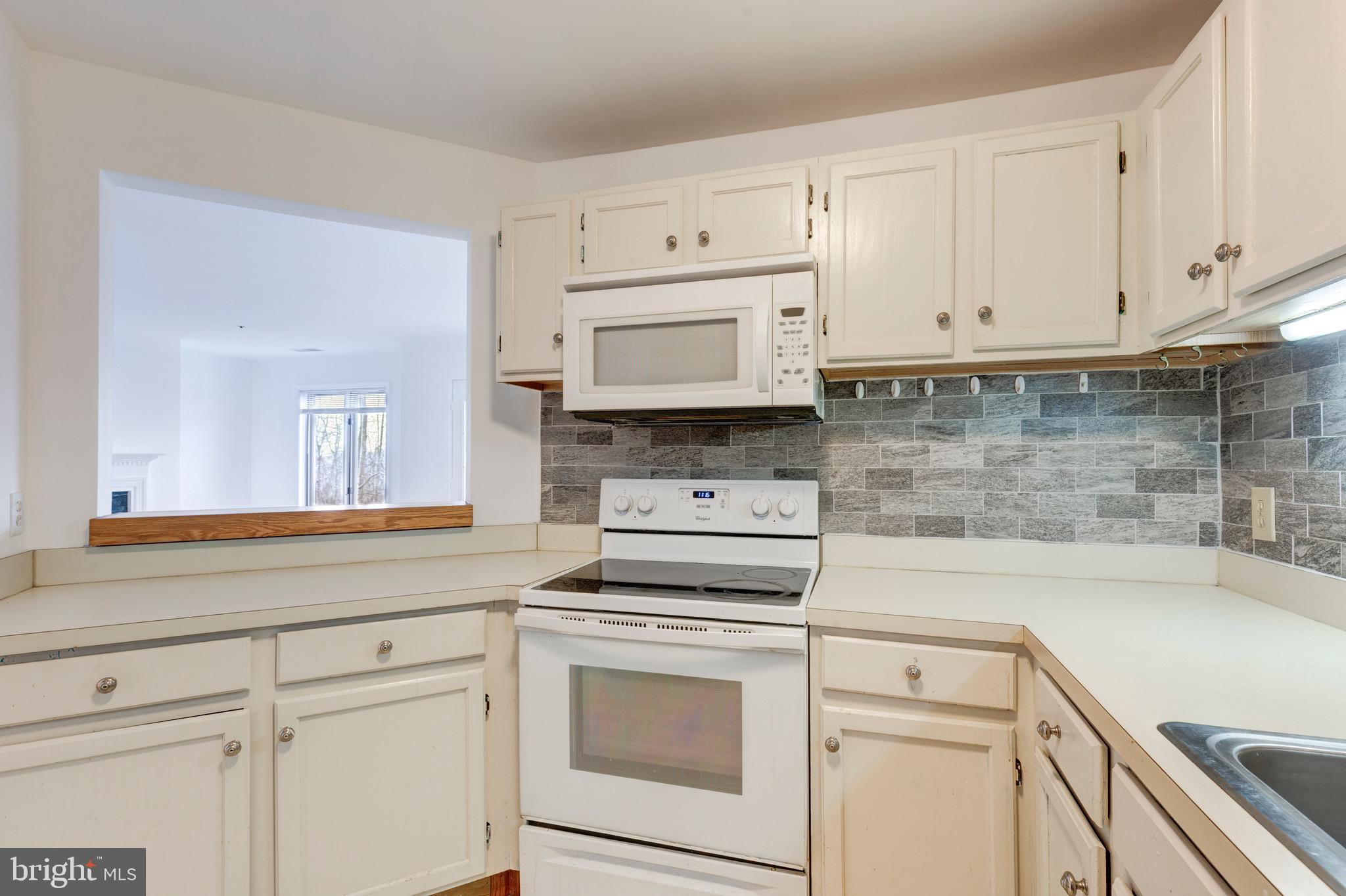 385 Pleasanton Road, Unit B22 Westminster, MD 21157 - Photo 9 of 35 a kitchen with white cabinets and white appliances