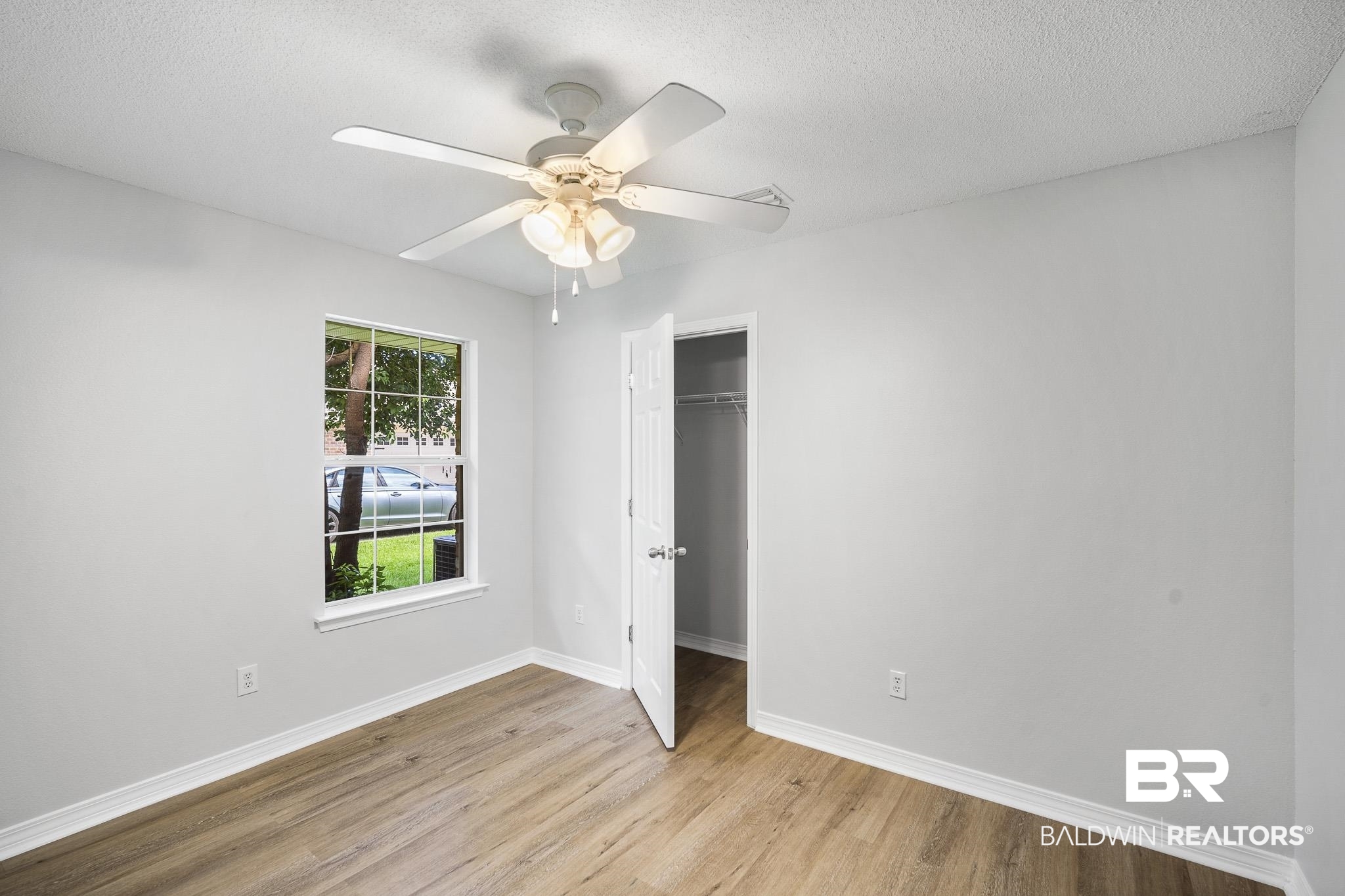 9814 Woolrich Avenue Fairhope, AL 36532 - Photo 15 of 29 Unfurnished bedroom with a textured ceiling, ceiling fan, light hardwood / wood-style floors, and a closet