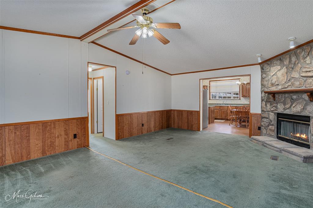 174 Bethel Road Frierson, LA 71027 - Photo 10 of 23 a view of a livingroom with a fireplace a ceiling fan and windows