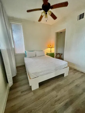 a bedroom with a bed and wooden floor