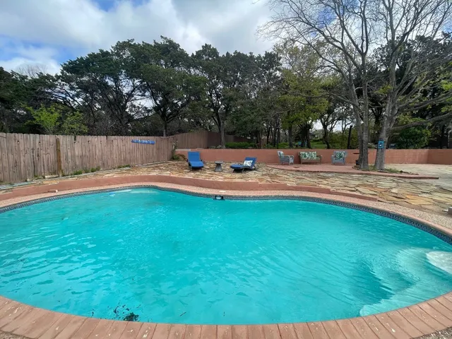 a view of a backyard with wooden fence