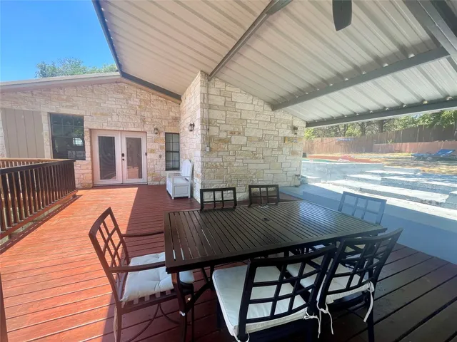 a view of a patio with table and chairs with wooden floor and fence