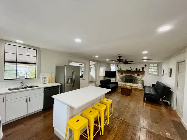 a large living room with stainless steel appliances granite countertop furniture and a kitchen view