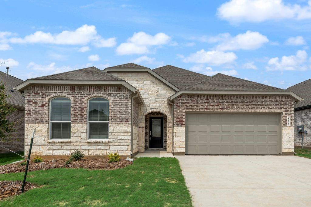 3009 Dutch Road Providence Village, TX 76227 - Photo 2 of 19 Contemporary exterior featuring a brick and stone facade, arched windows, an attached two-car garage, and a concrete driveway