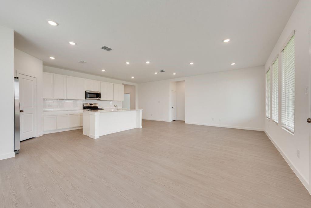 3009 Dutch Road Providence Village, TX 76227 - Photo 4 of 19 Open-concept living space with light wood-finish flooring, recessed lighting, and bright white walls