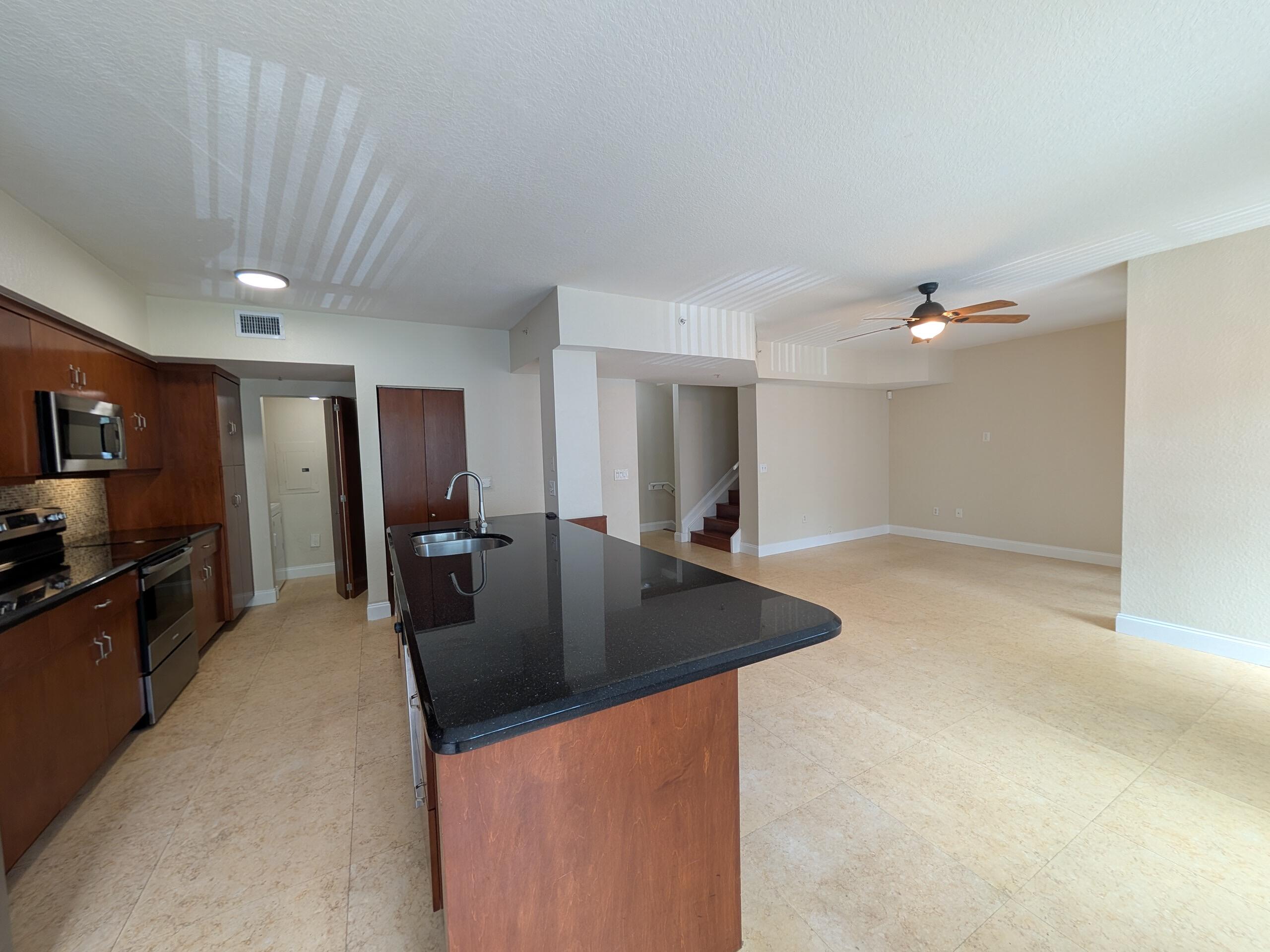 6966 West Sample Road, Unit 6966 Coral Springs, FL 33067 - Photo 5 of 58 a kitchen with stainless steel appliances granite countertop a sink a stove and a refrigerator
