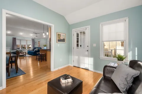 a living room with furniture and a wooden floor