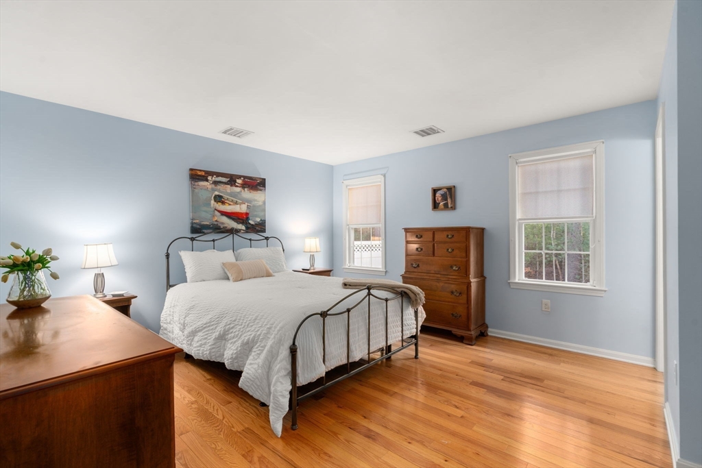 42 Brewster Road, Unit 42 Stoughton, MA 02072 - Photo 5 of 28 a bedroom with a bed and wooden floor