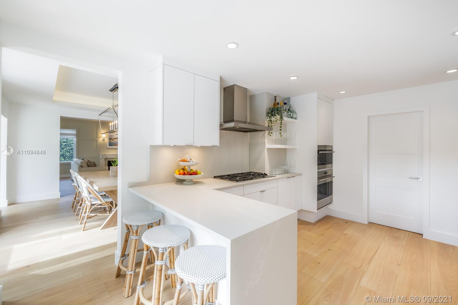 5235 North Bay Road Miami Beach, FL 33140 - Photo 8 of 22 a kitchen with a stove a refrigerator and a dining table