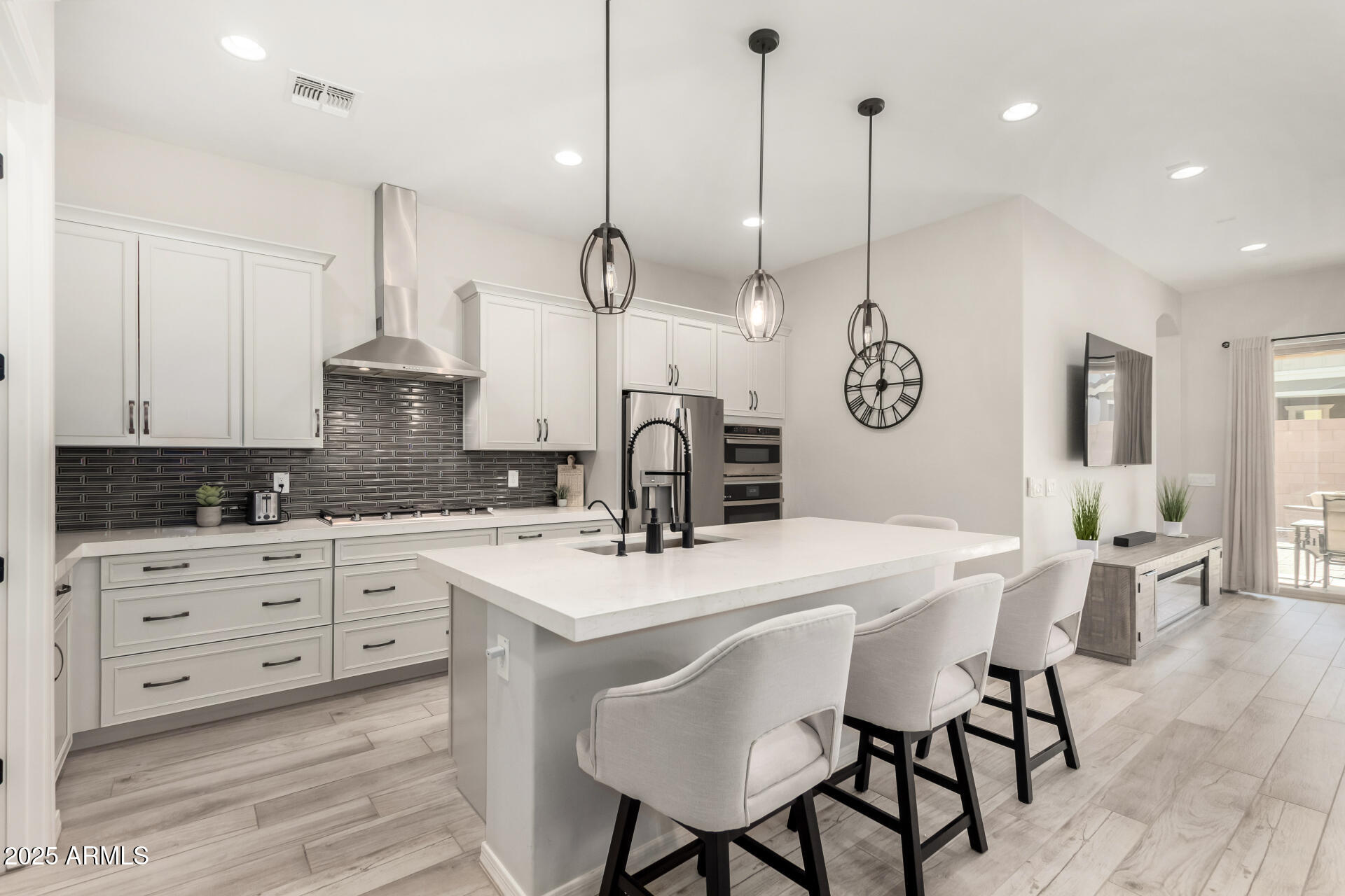 23129 East Carriage Way Queen Creek, AZ 85142 - Photo 12 of 50 a kitchen with stainless steel appliances kitchen island granite countertop a table chairs and white cabinets