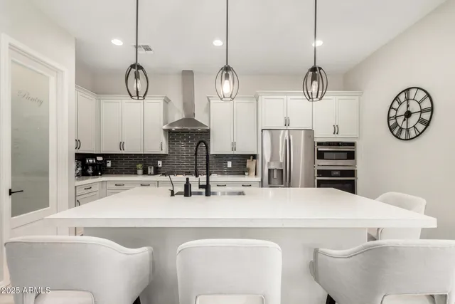 a large kitchen with a large center island and stainless steel appliances