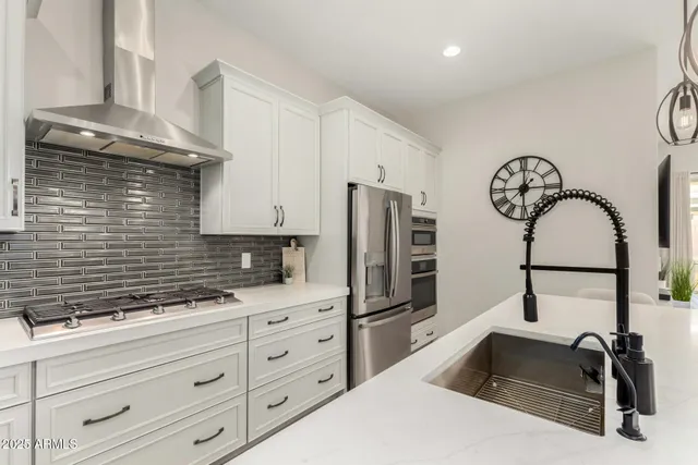 a kitchen with granite countertop white cabinets and stainless steel appliances