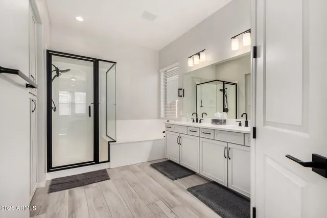 a spacious bathroom with a double vanity sink a mirror and a bathtub
