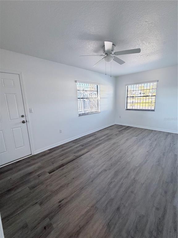 2924 West Kathleen Street Tampa, FL 33607 - Photo 17 of 20 an empty room with wooden floor ceiling fan and windows