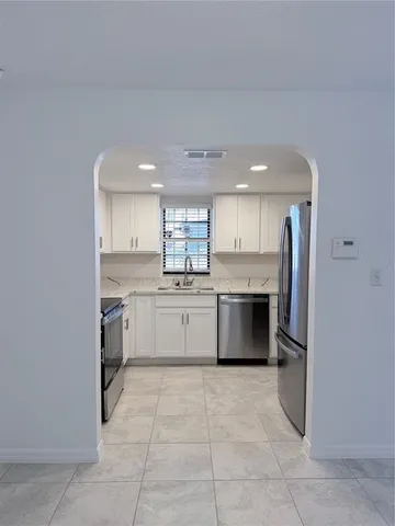 a large kitchen with a stove top oven and cabinets