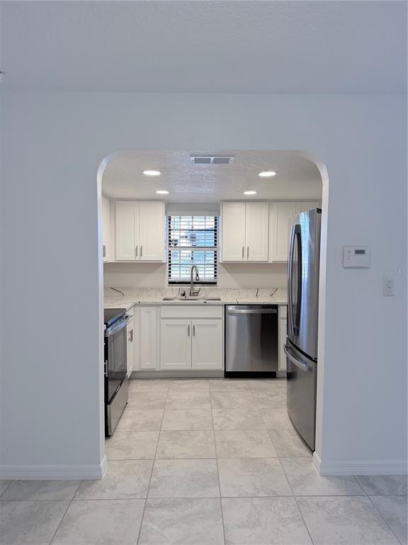 2924 West Kathleen Street Tampa, FL 33607 - Photo 6 of 20 a large kitchen with a stove top oven and cabinets