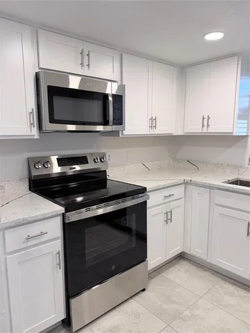 a kitchen with white cabinets and stainless steel appliances