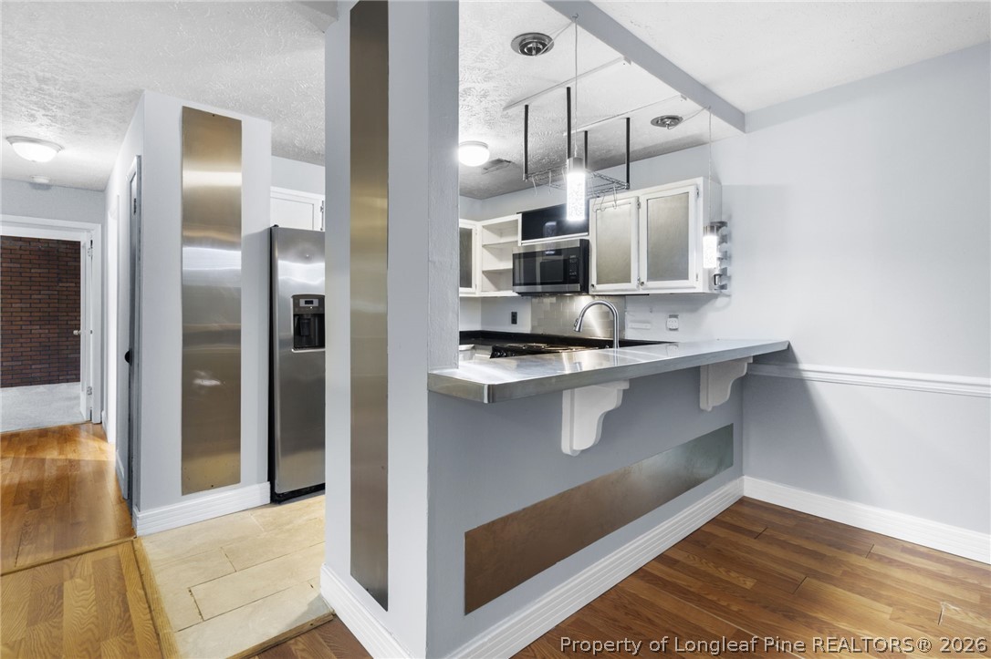 1908 Tryon Drive, Unit 1 Fayetteville, NC 28303 - Photo 11 of 29 a kitchen with stainless steel appliances kitchen island a refrigerator sink and microwave