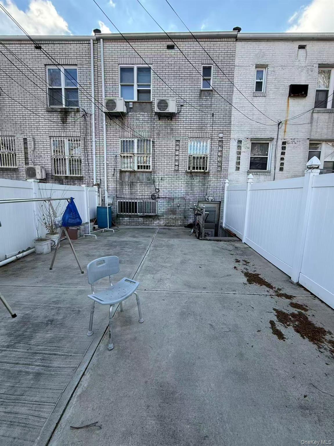 146-27 61st Road Queens, NY 11367 - Photo 15 of 17 Rear view of property featuring brick siding and a patio area