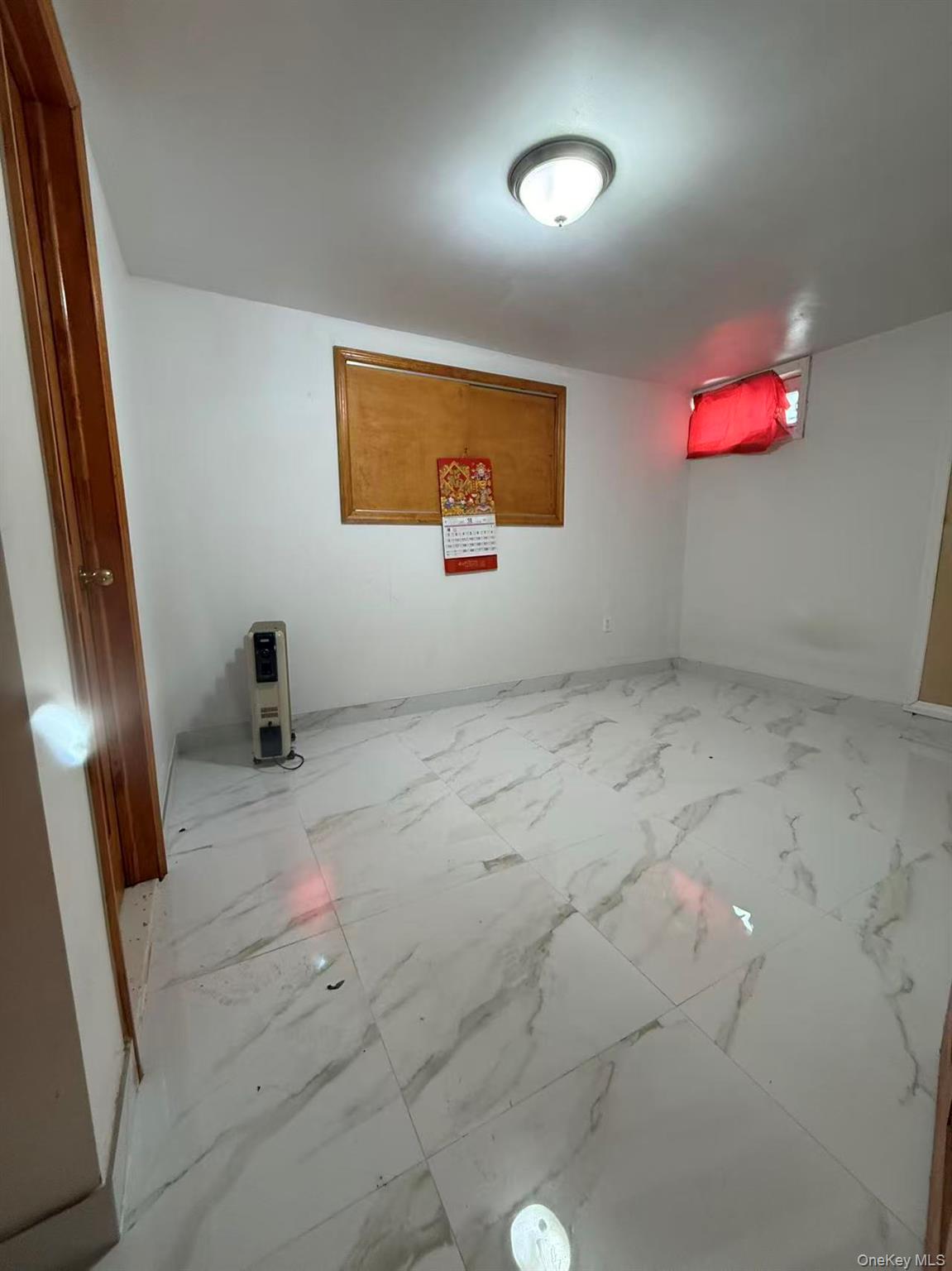 146-27 61st Road Queens, NY 11367 - Photo 4 of 17 Spare room with light marble finish flooring and baseboards
