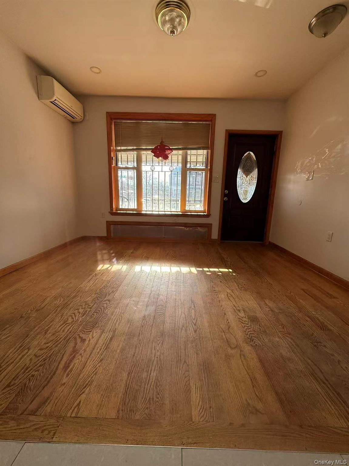146-27 61st Road Queens, NY 11367 - Photo 9 of 17 Entrance foyer with wood finished floors, a wall mounted AC, and recessed lighting