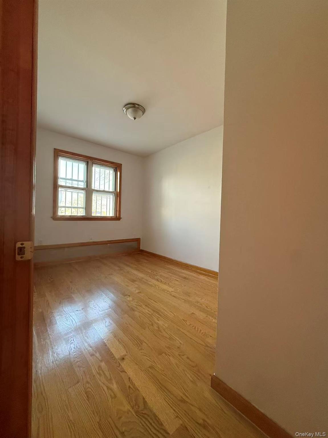 146-27 61st Road Queens, NY 11367 - Photo 10 of 17 Spare room with baseboards and light wood-type flooring