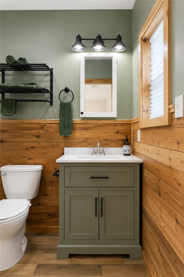 605 Hampton Street Iva, SC 29655 - Photo 8 of 16 A striking modern bathroom vanity and wood paneling create a warm, inviting ambiance.