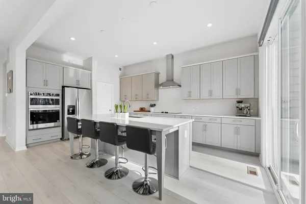 a large kitchen with stainless steel appliances a sink and a large window
