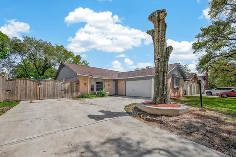 a backyard of a house with table and chairs plants
