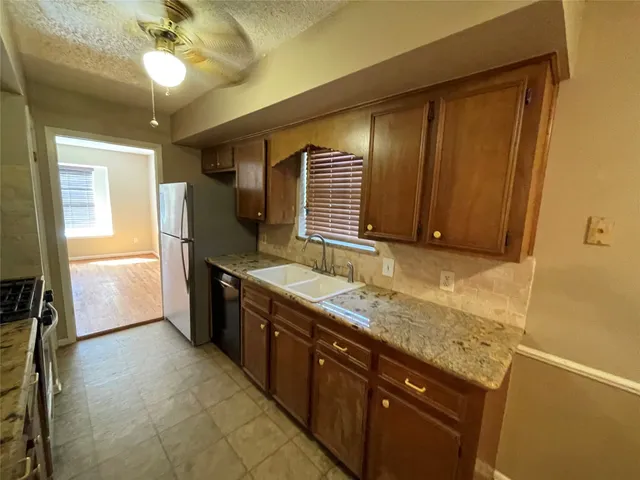 a kitchen with granite countertop a sink stainless steel appliances a counter space and cabinets