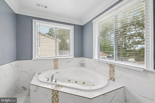 a white bath tub sitting in a bathroom next to a window