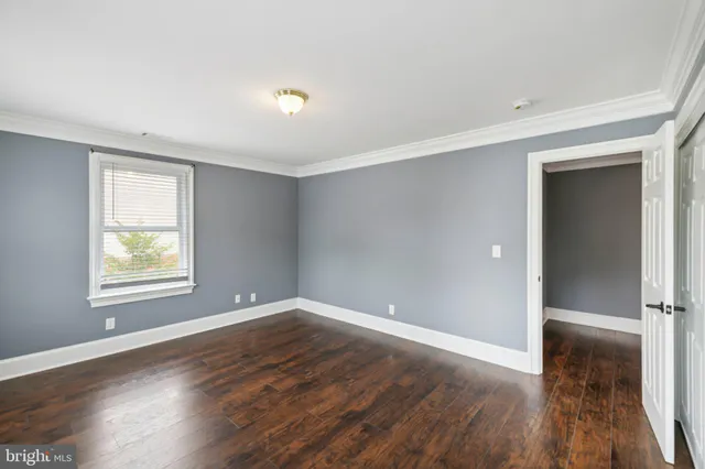 an empty room with wooden floor and a window