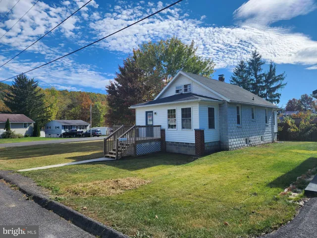 a view of a house with a yard and sitting area