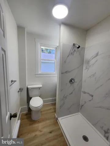 a kitchen with stainless steel appliances granite countertop a sink a stove a refrigerator cabinets and a window