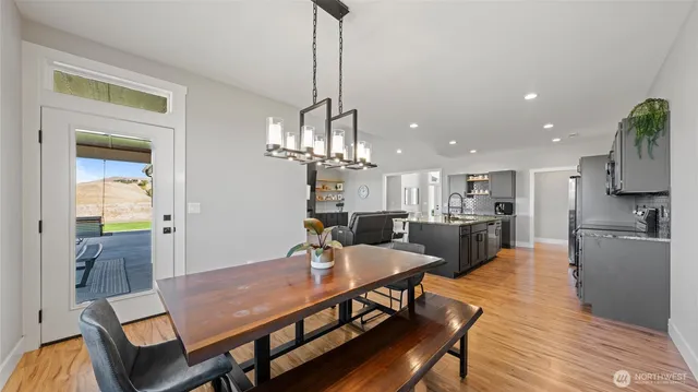 a view of a dining room and livingroom with furniture wooden floor a chandelier