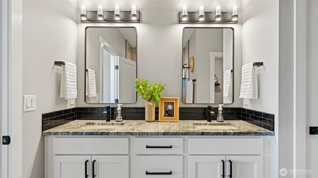 a bathroom with a granite countertop sink and a mirror