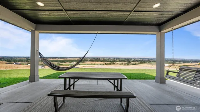 a view of a swimming pool with a table and chairs under an umbrella