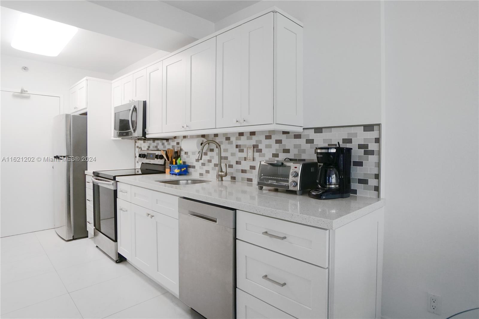100 Lincoln Road, Unit 436 Miami Beach, FL 33139 - Photo 6 of 11 a kitchen with appliances cabinets and a sink