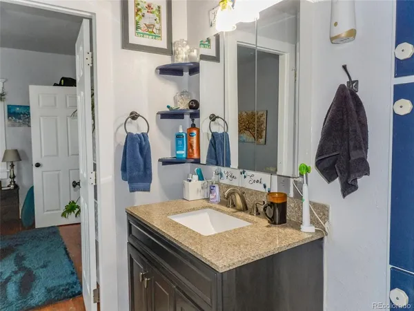 a bathroom with a granite countertop sink and a mirror