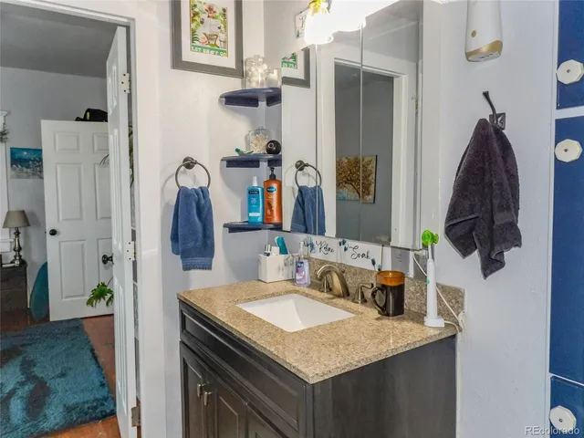 a bathroom with a granite countertop sink and a mirror